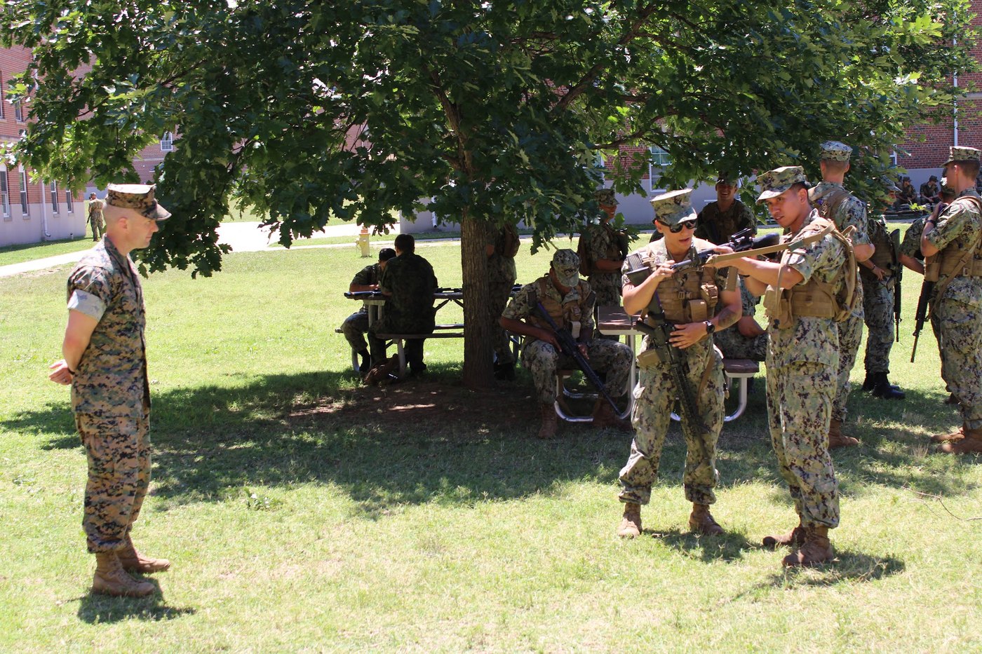 Marine instructor supervises midshipmen during weapons handling