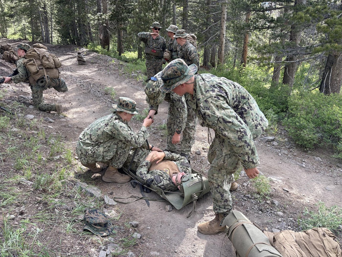 Midshipmen practice casualty evacuation on a mountain trail during MWTC