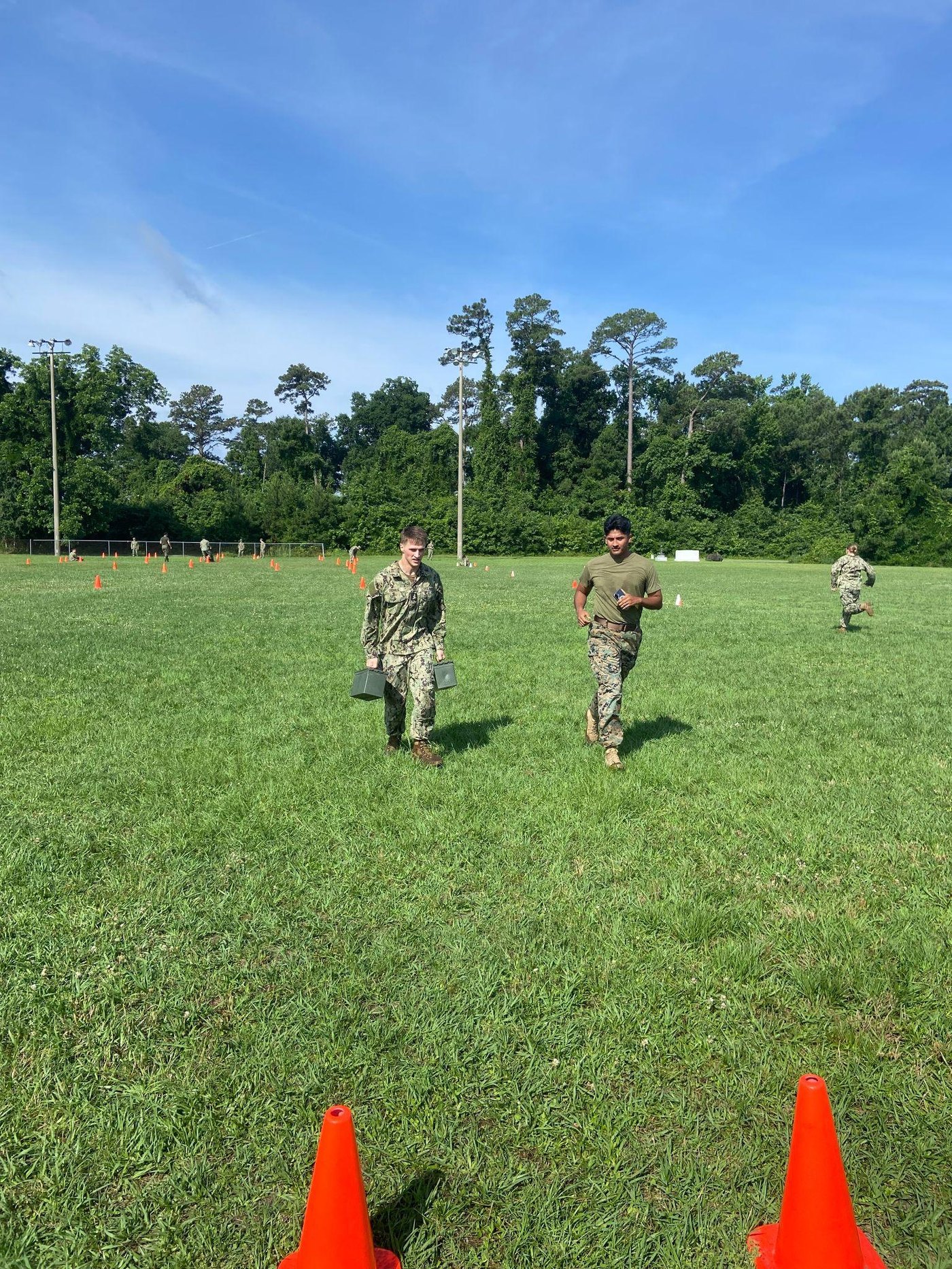 Midshipmen carry ammo cans during maneuver-under-fire training