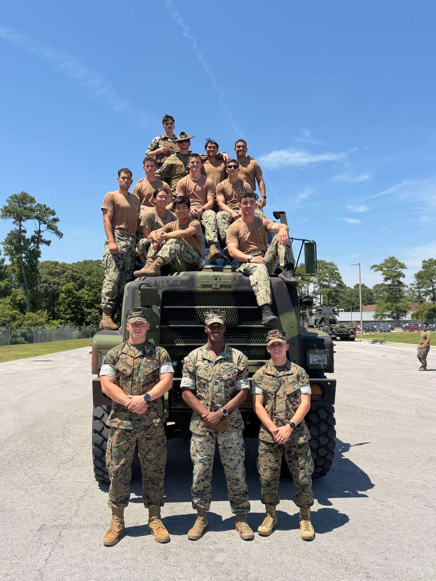 Midshipmen pose with a Marine Corps tactical truck during PROTRAMID